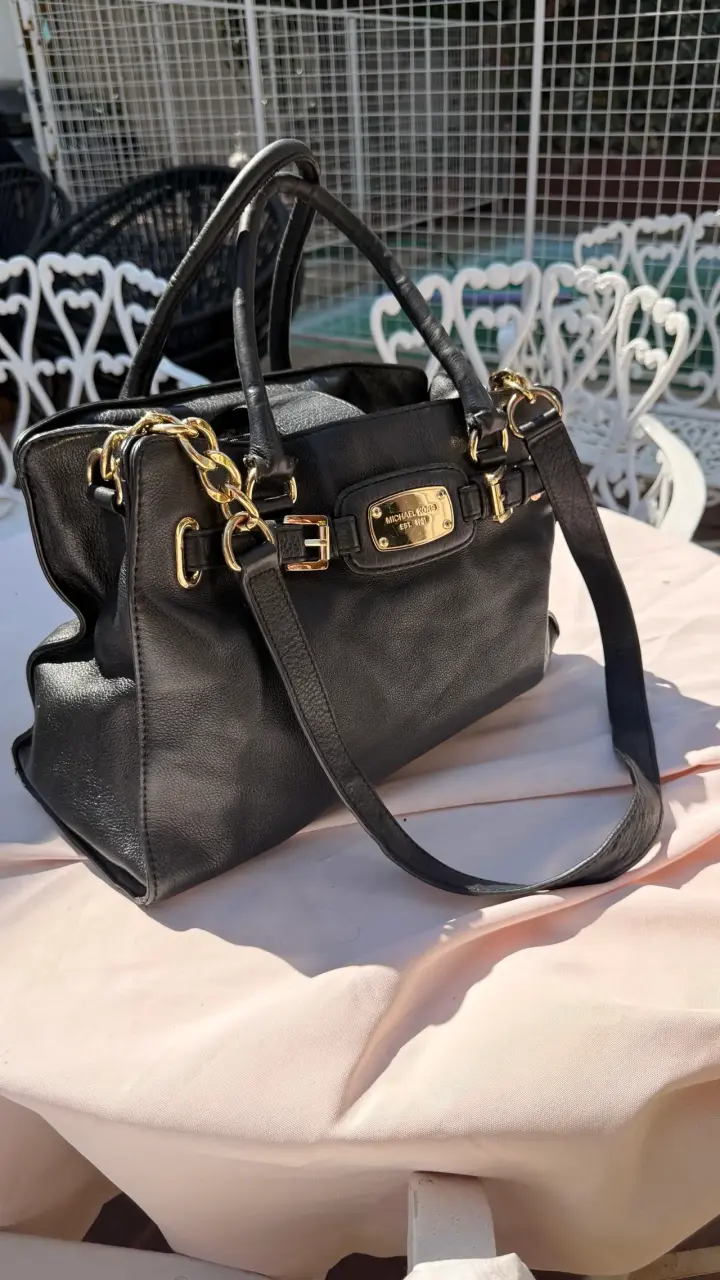 Bolso de cuero negro Michael Kors con detalles dorados
