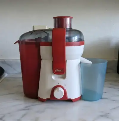 Extractor de jugo Oster rojo y blanco - miniatura 1