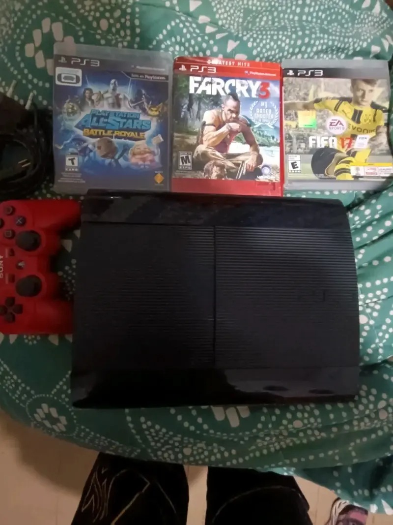 Consola PS3 con juegos y control rojo
