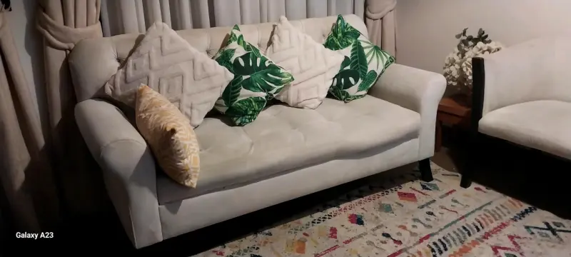 Sofá de tela beige con cojines decorativos - 1