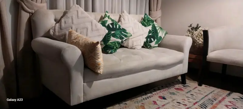 Sofá de tela beige con cojines decorativos - 2