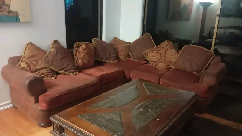 Sofá seccional de tela marrón con cojines decorativos