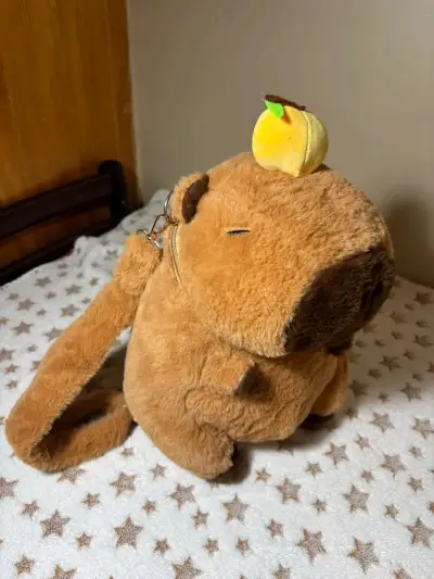 Mochila de peluche capibara con adorno de fruta - miniatura 1