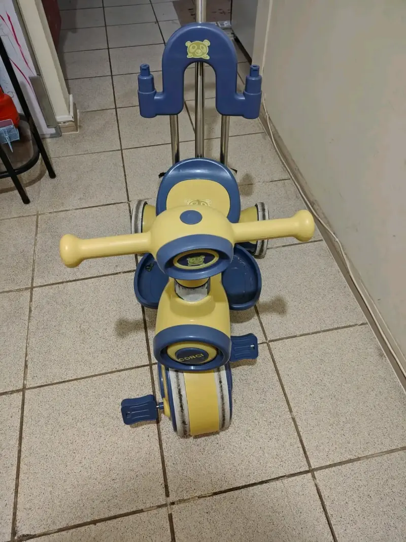 Triciclo infantil amarillo y azul con manillar