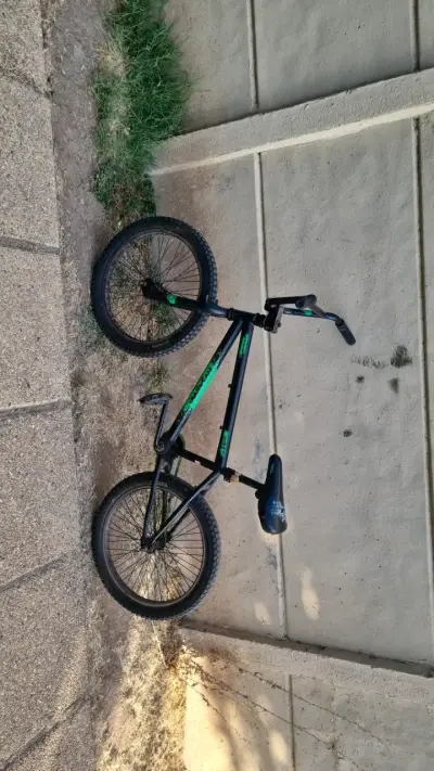Bicicleta BMX negra con detalles verdes - miniatura 1
