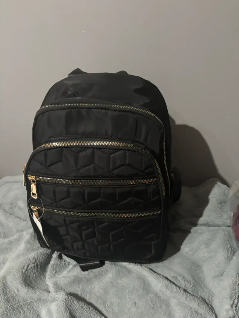 Mochila negra con diseño acolchado y cierres dorados - 1