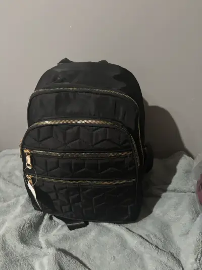 Mochila negra con diseño acolchado y cierres dorados - miniatura 1