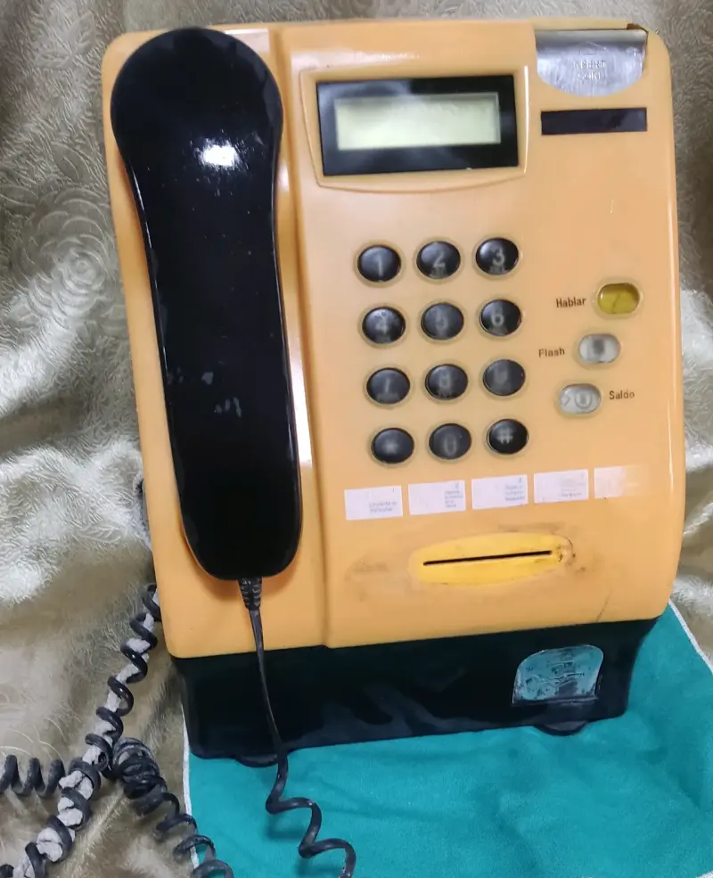 Teléfono público antiguo amarillo con teclado numérico - 1
