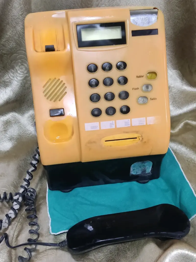 Teléfono público antiguo amarillo con teclado numérico - 2