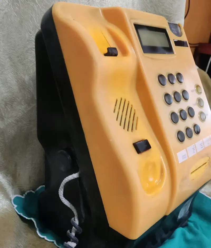 Teléfono público antiguo amarillo con teclado numérico - 3