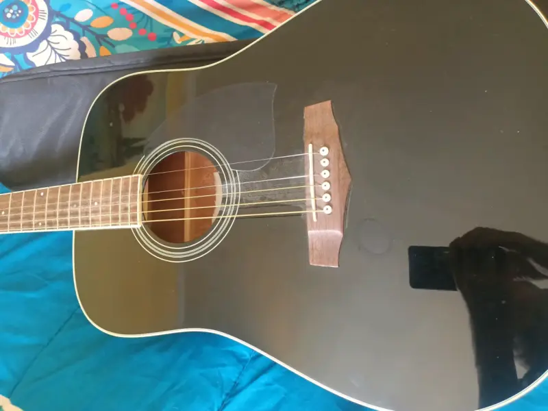 Guitarra acústica negra con funda