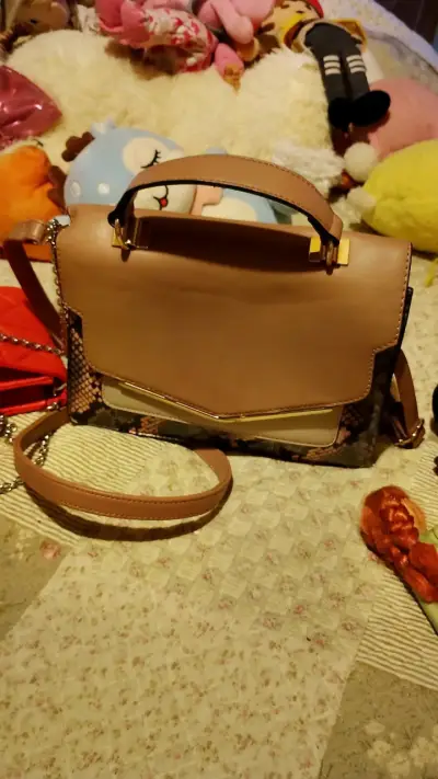 Bolso de mano beige con diseño de serpiente - miniatura 1