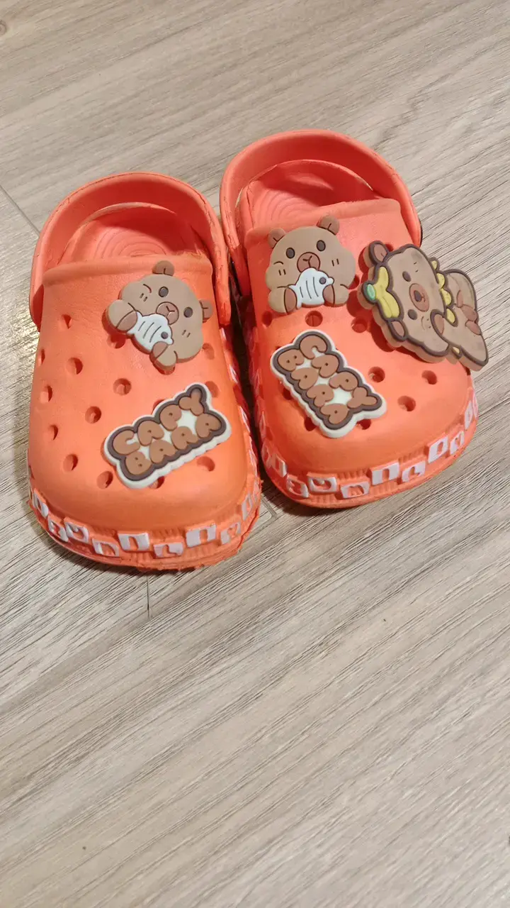 Sandalias infantiles naranjas con diseño de capibara