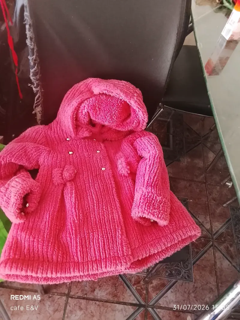 Abrigo infantil rosado con capucha y pompones