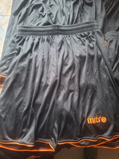 Shorts deportivos negros Mitre con detalles naranjas - miniatura 1