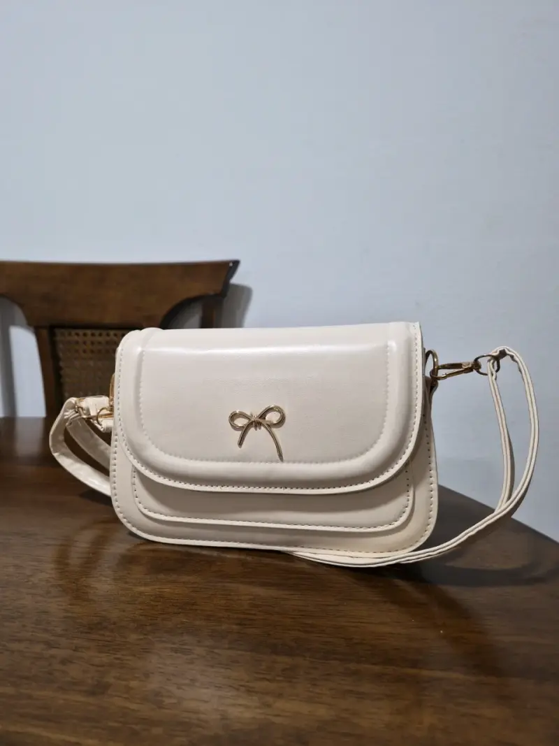 Cartera beige con diseño de lazo elegante