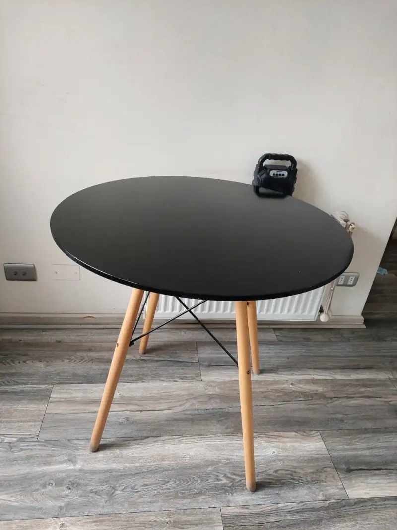 Mesa redonda negra con patas de madera