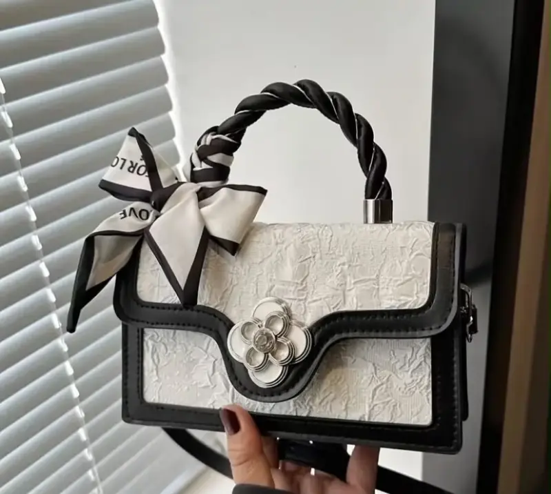 Cartera de mano elegante con lazo decorativo