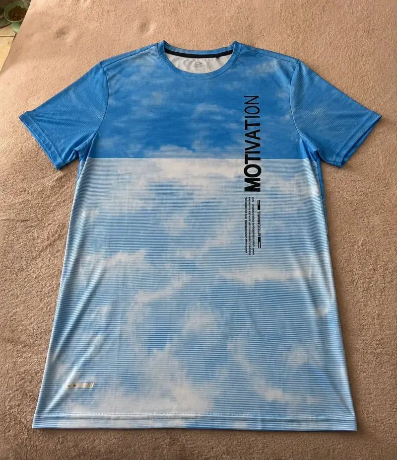 Polera deportiva azul con diseño de nubes - 1