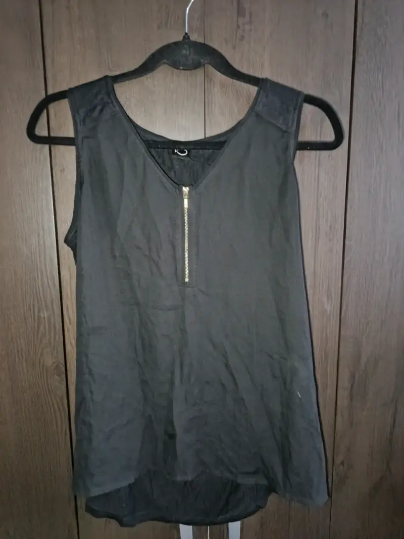 Blusa sin mangas negra con cierre frontal