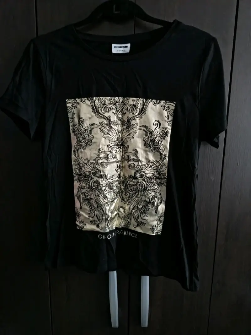 Polera negra con diseño dorado - 1