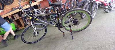 Bicicleta de montaña negra con llantas verdes - miniatura 2