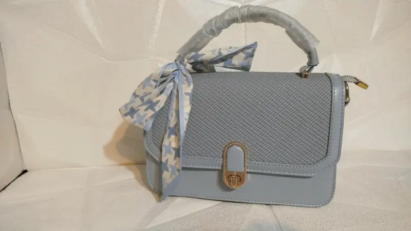 Cartera de mano azul con lazo decorativo - 1