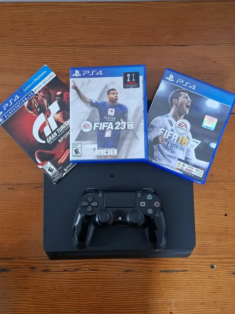 Consola PS4 con control y juegos FIFA 23, FIFA 18 y Gran Turismo