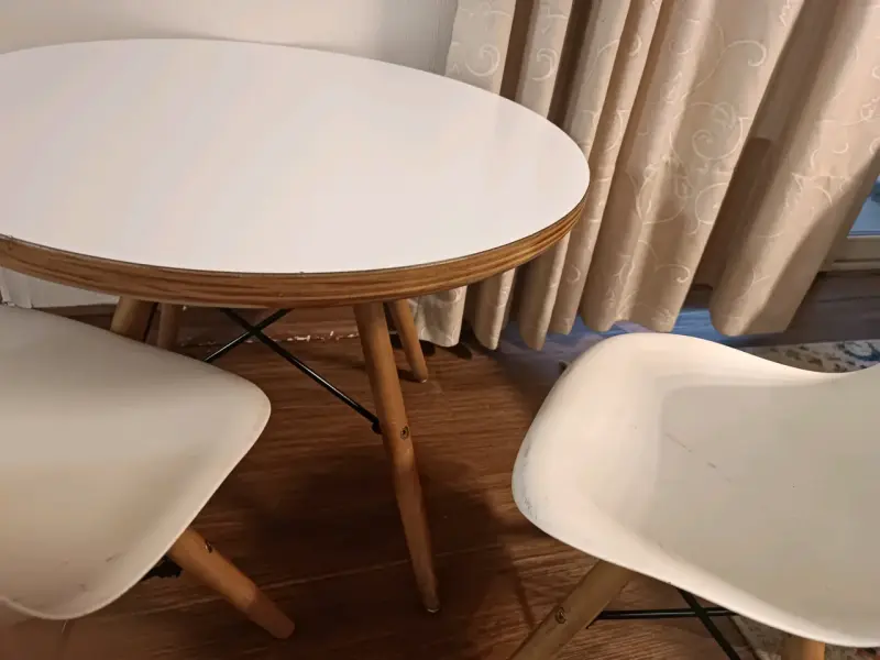 Mesa redonda con sillas blancas de madera - 1