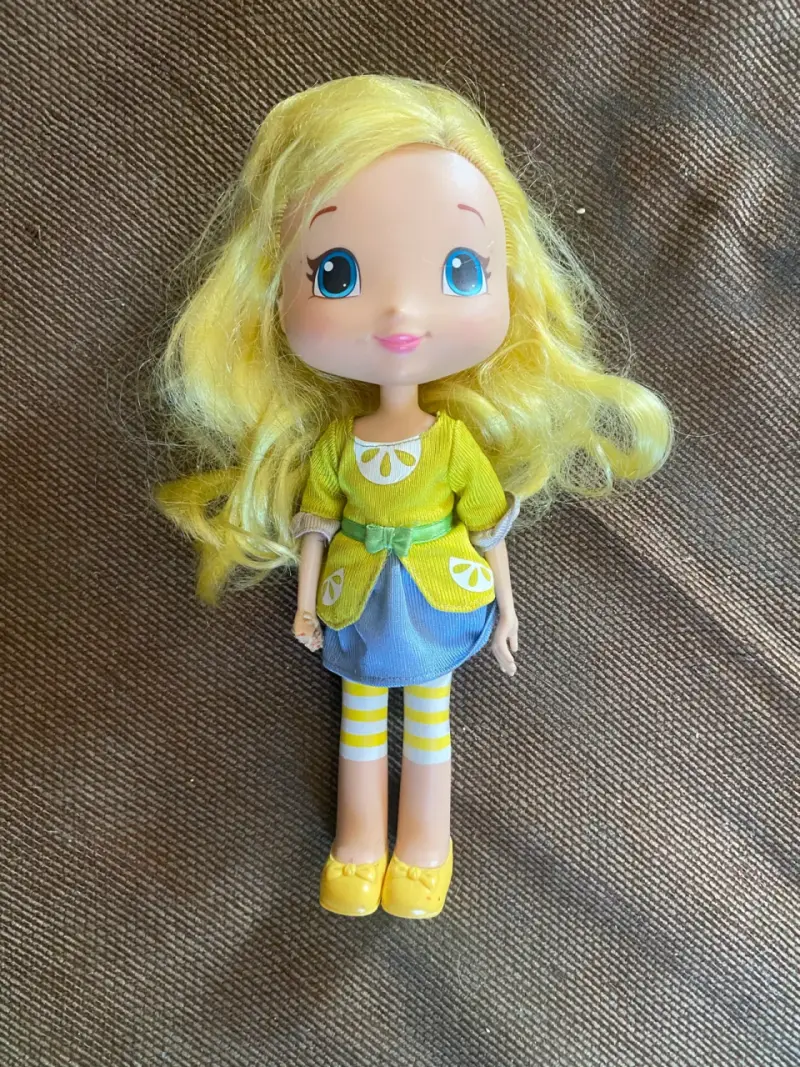 Muñeca de juguete con vestido amarillo y azul