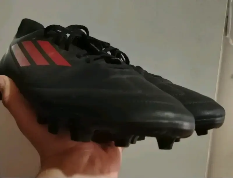 Botines de fútbol negros con detalles rojos - 1