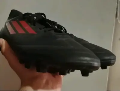 Botines de fútbol negros con detalles rojos - miniatura 1