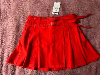 Falda roja plisada con cinturón - miniatura 1