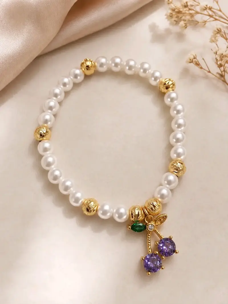 Pulsera de perlas con detalles dorados y colgante de cerezas