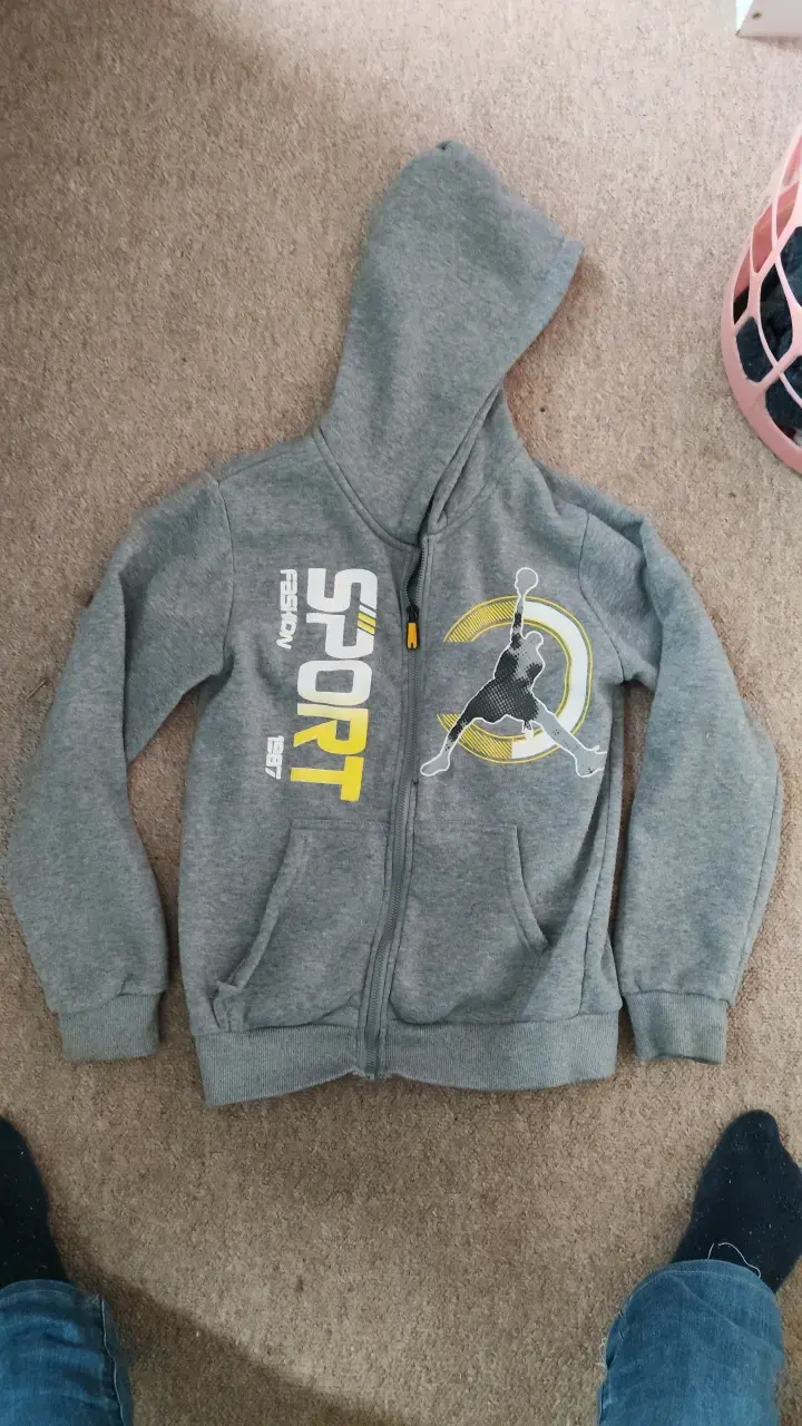 Polerón gris con capucha y diseño deportivo