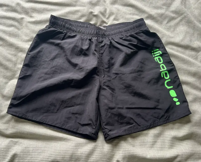 Shorts deportivos negros con logo verde - 1