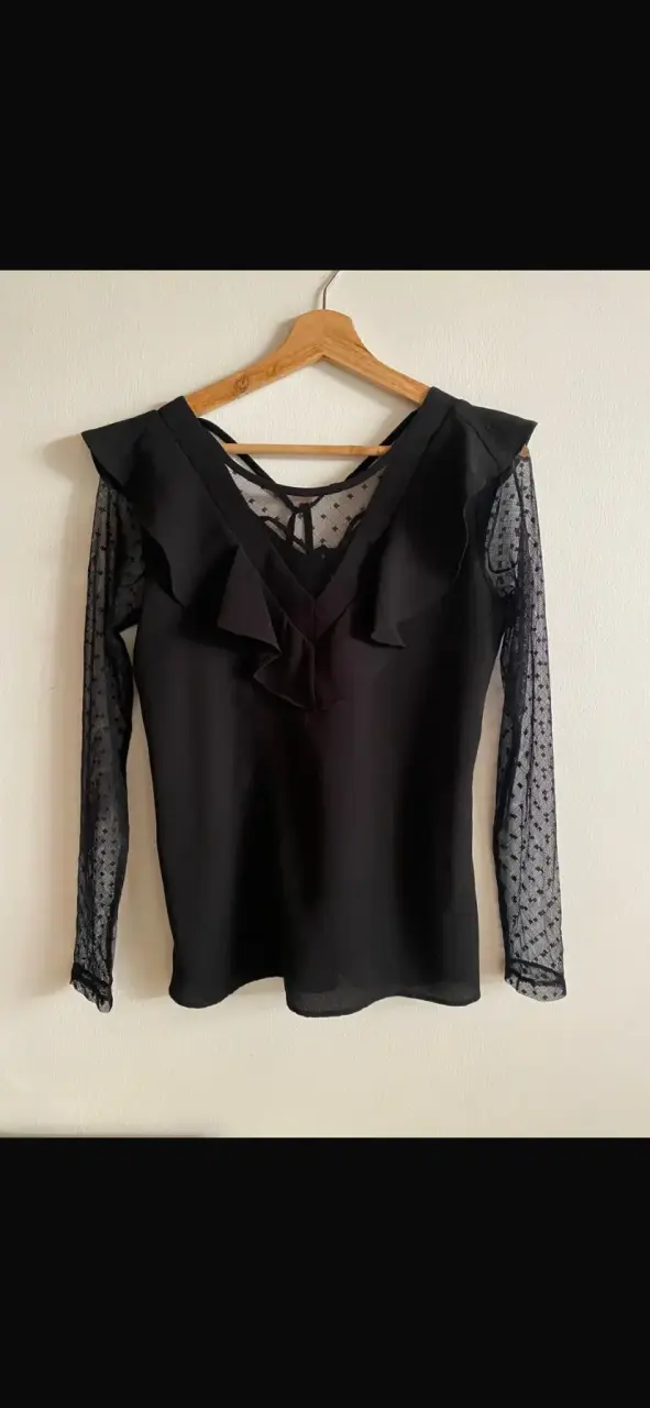 Blusa negra con mangas de encaje y volantes