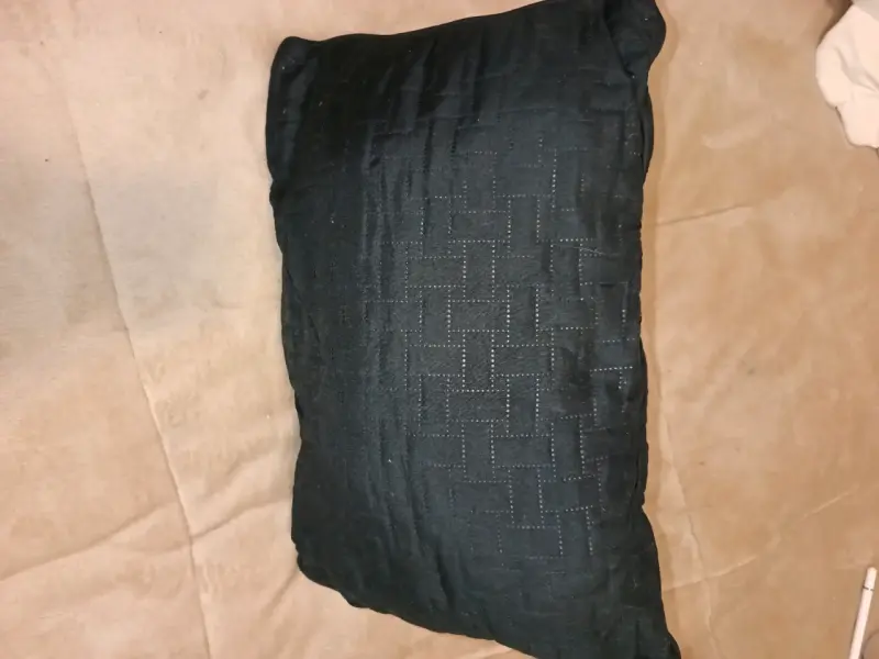 Cojín decorativo negro con diseño texturizado