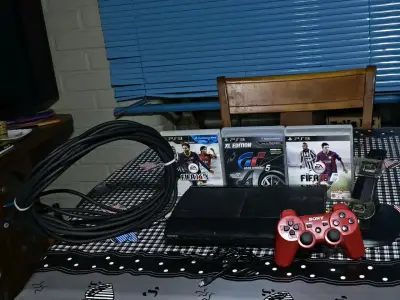 Consola PlayStation 3 con juegos y control rojo - miniatura 1