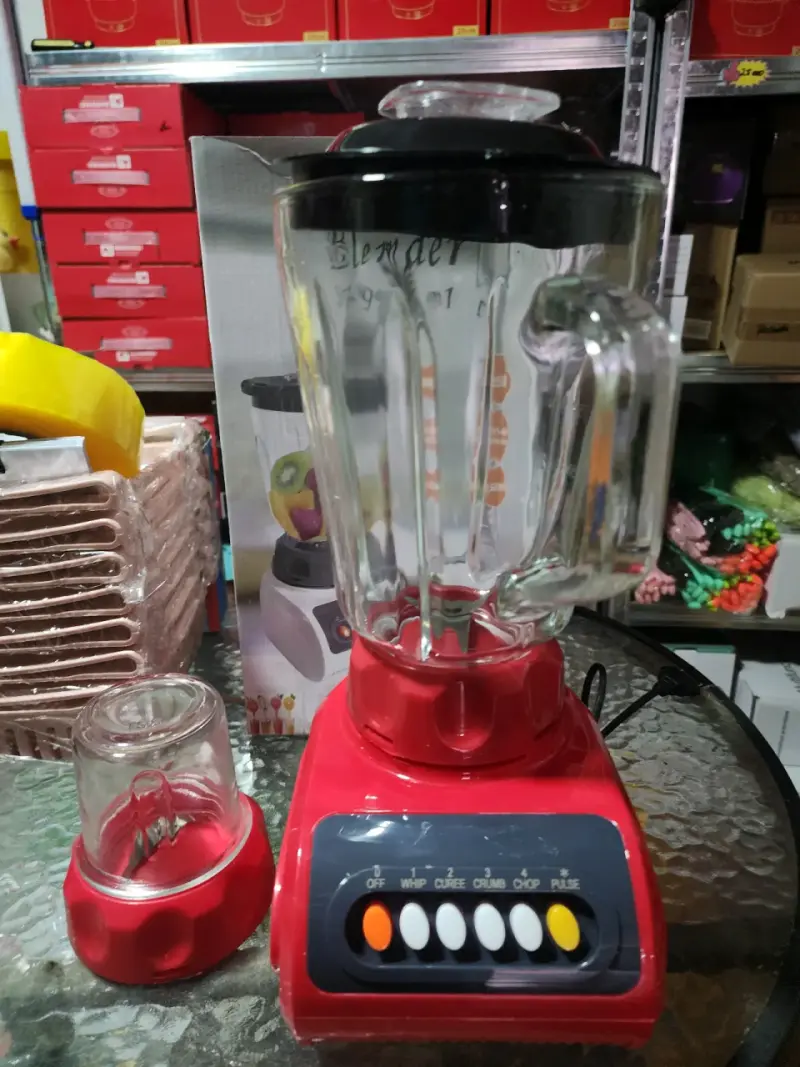 Licuadora roja con vaso de vidrio y accesorios