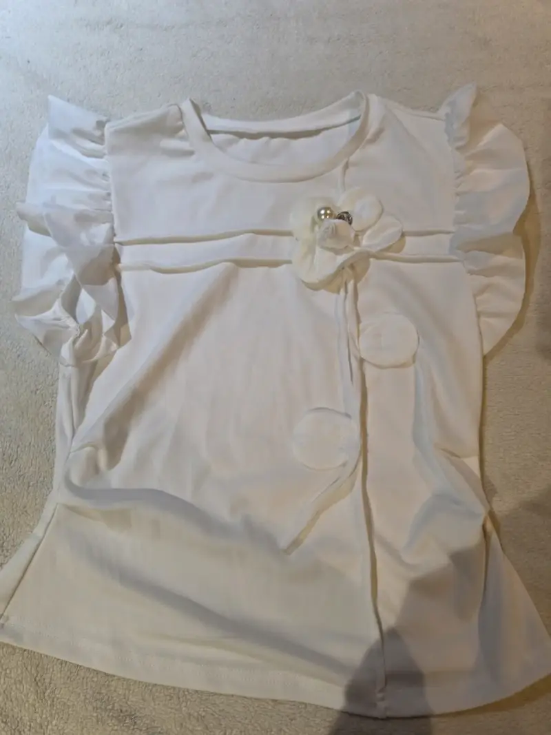 Blusa blanca con volantes y detalle floral - 1