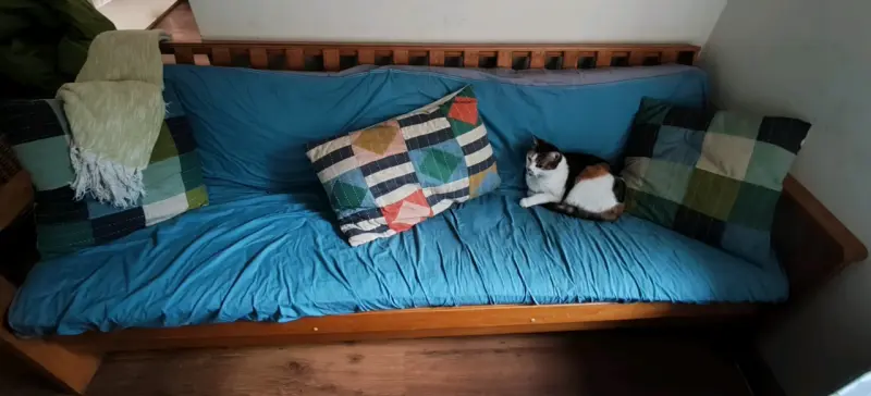 Sofá cama de madera con cojines coloridos - 1