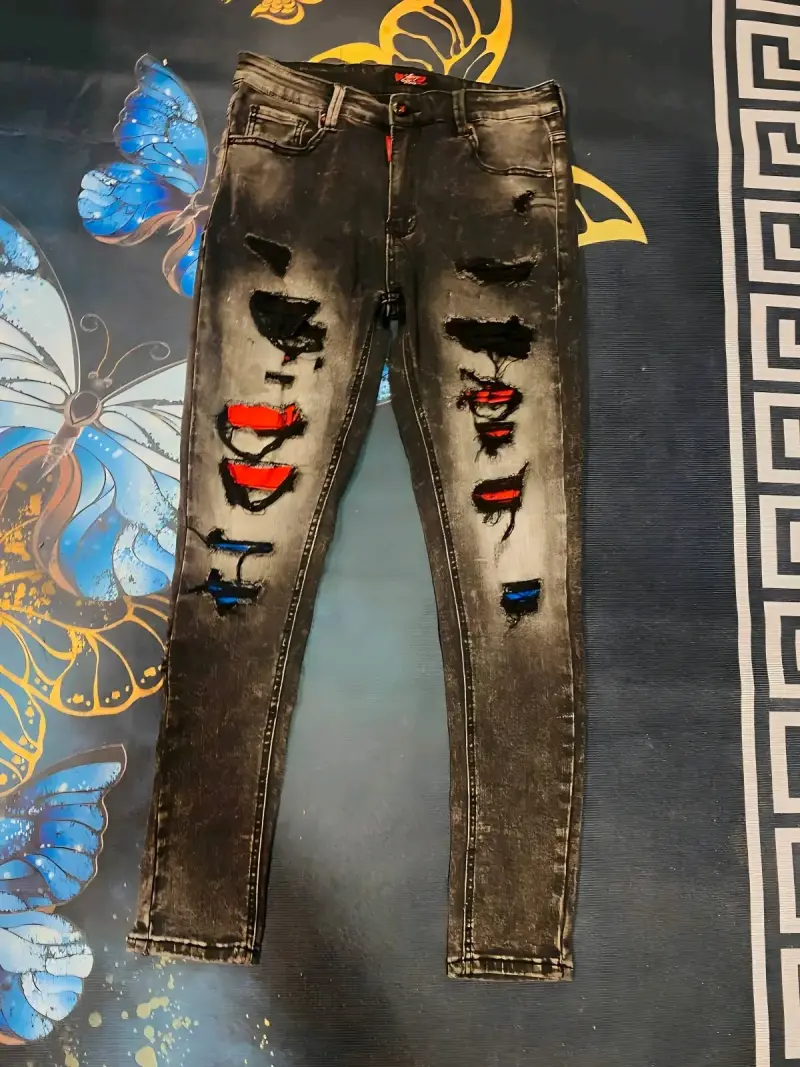 Jeans negros desgastados con detalles de colores