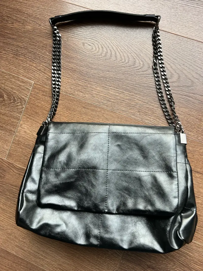 Bolso de cuero negro con cadena elegante. ZARA