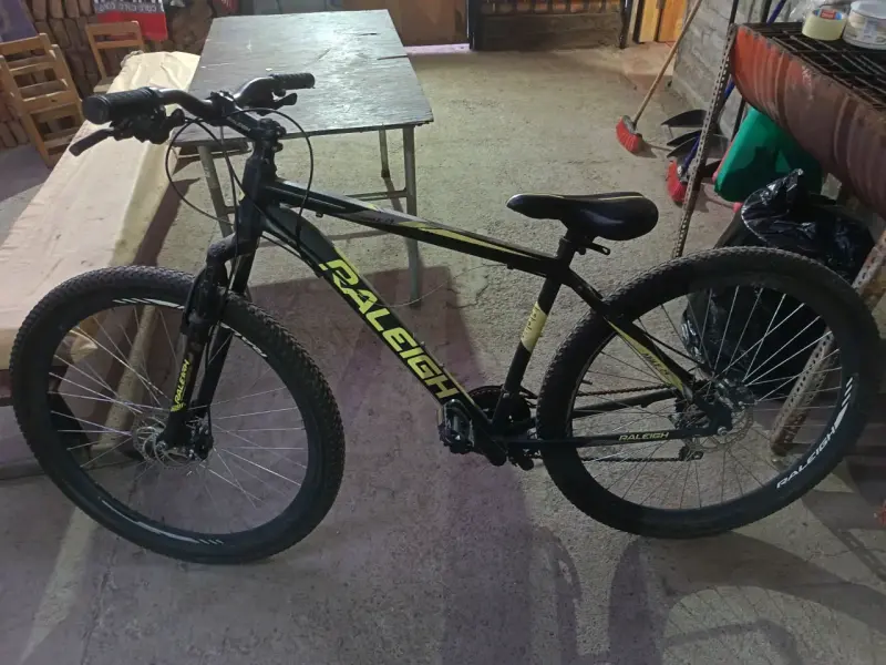 Bicicleta de montaña Raleigh negra con detalles amarillos
