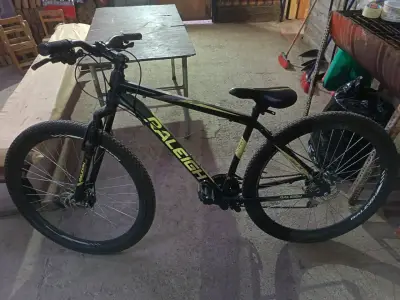 Bicicleta de montaña Raleigh negra con detalles amarillos - miniatura 1