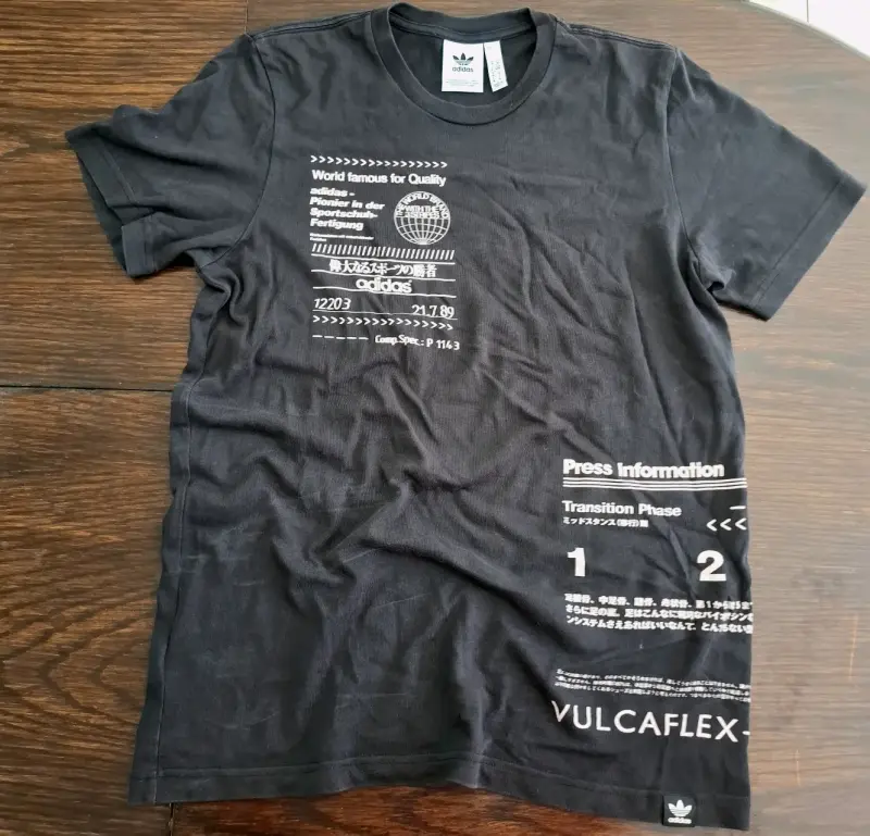 Polera negra Adidas con diseño gráfico - 1