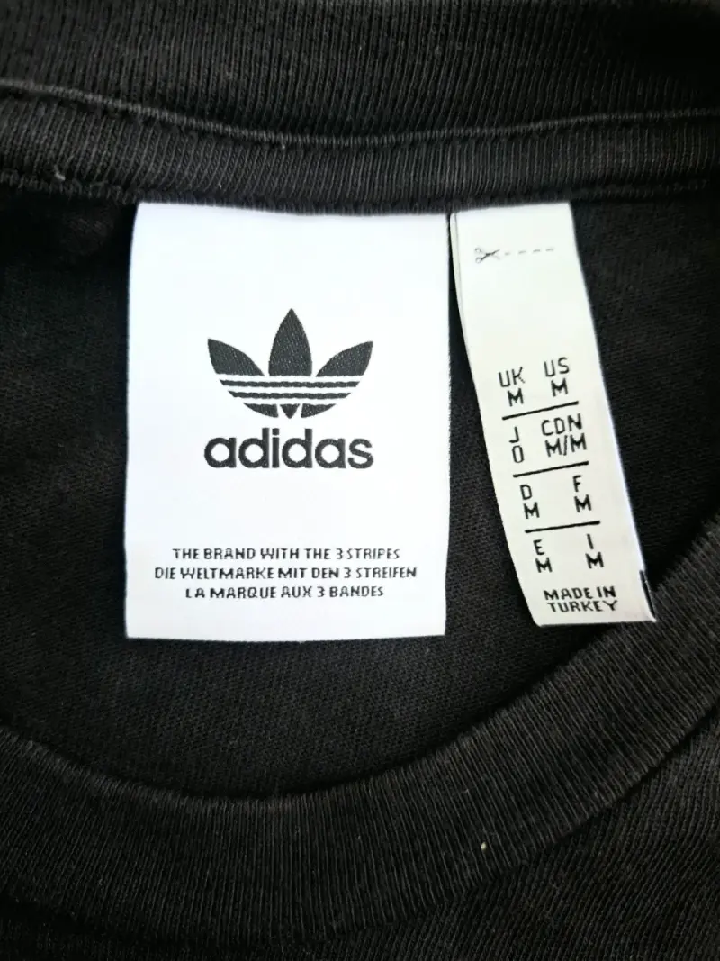 Polera negra Adidas con diseño gráfico - 3