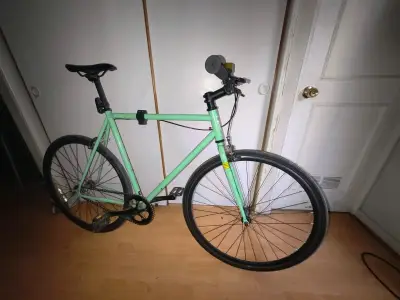 Bicicleta urbana verde con casco y candado - miniatura 1