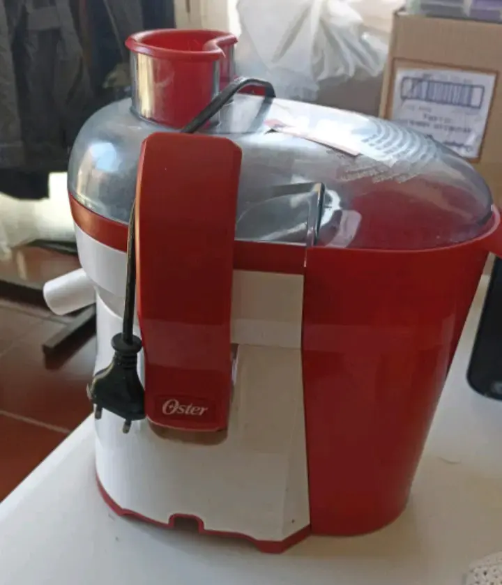 Extractor de jugos Oster rojo y blanco